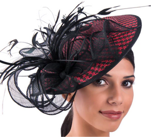 Woman wearing a black and red houndstooth fascinator hat adorned with feathers and netting